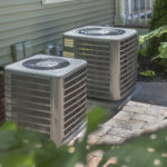 Two HVAC units outside of a home.